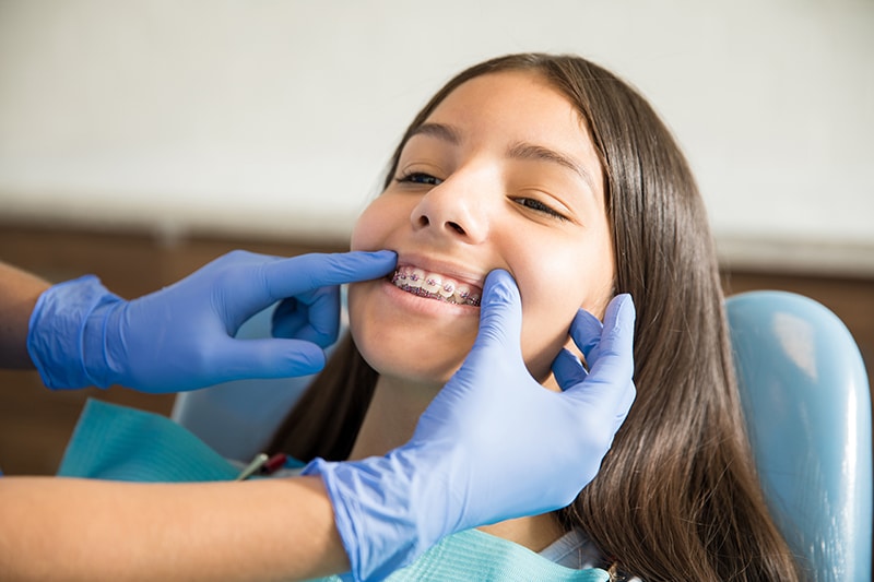 girl with braces being examined Surgical orthodontics